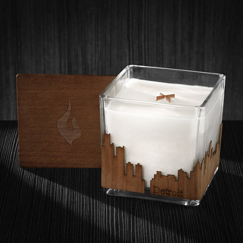 Image of a 4x4x4 soy candle featuring a mahogany scent, crackling wood wick, with a wood lid and a Detroit skyline wrap design.